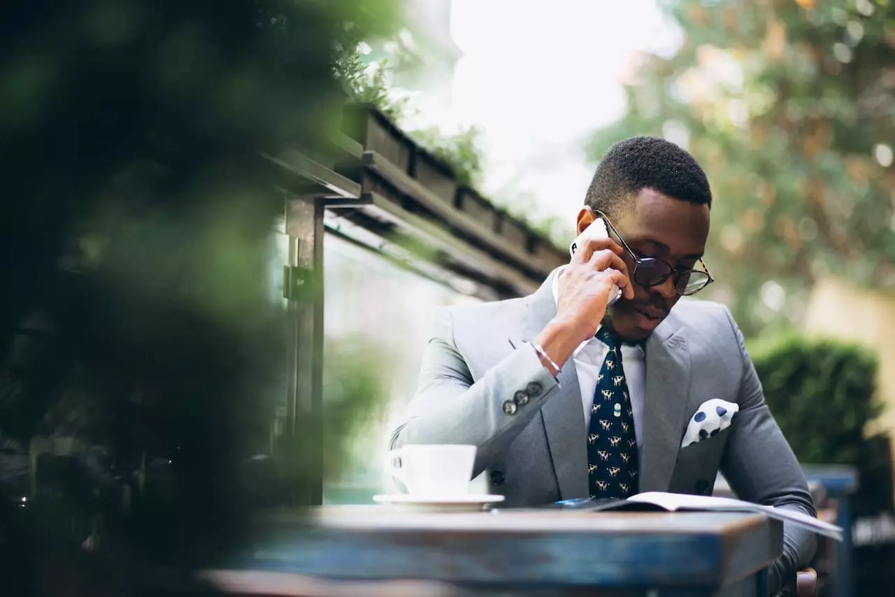Entrepreneur africain innovant en discussion téléphonique au café