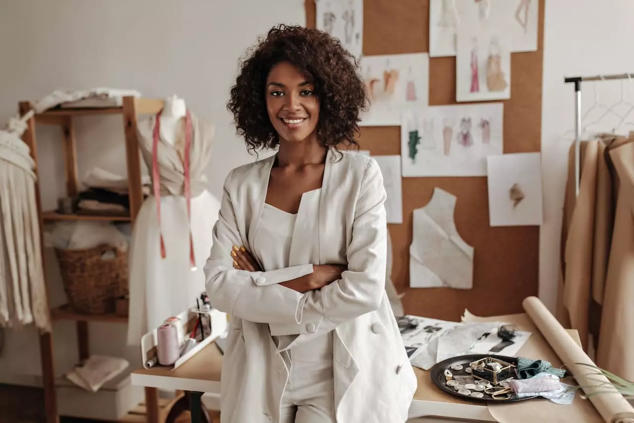 Femme entrepreneure africaine souriante dans son atelier de mode