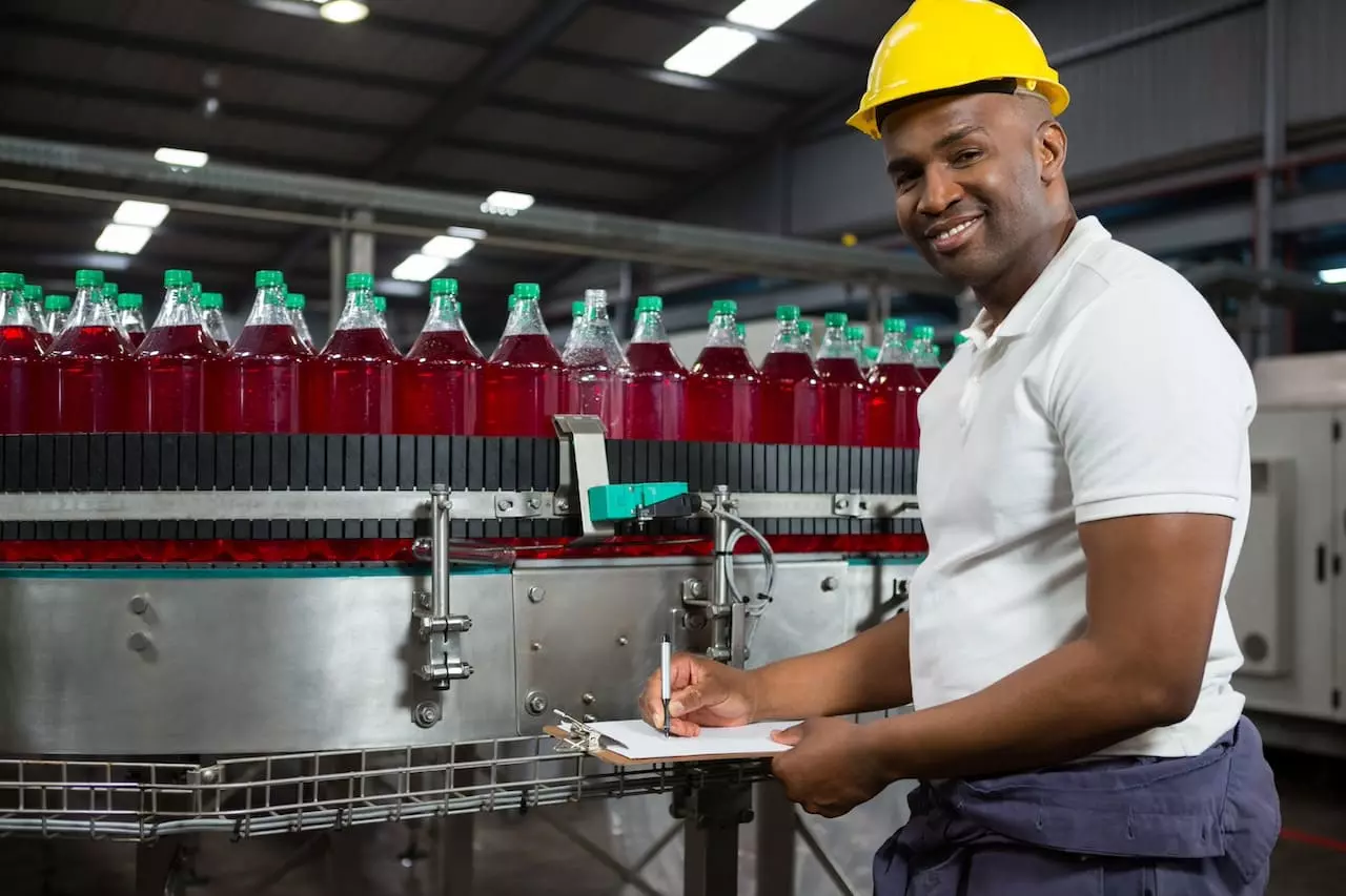 Entrepreneur africain vérifiant la production dans une usine de boissons