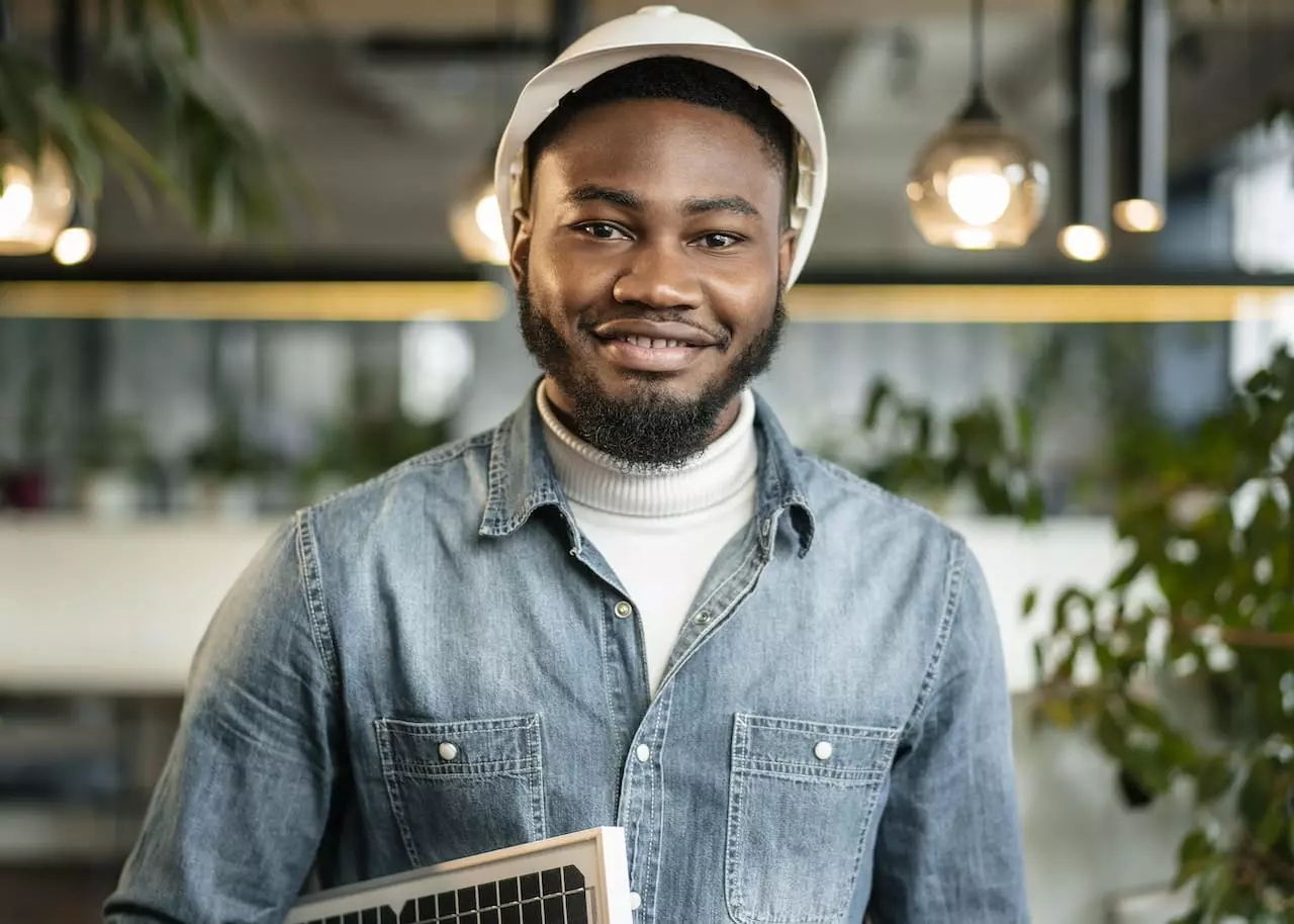 Jeune investisseur africain engagé en tenue professionnelle avec casque de sécurité