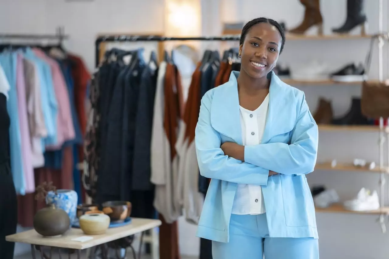 Entrepreneure africaine confiante dans sa boutique de vêtements